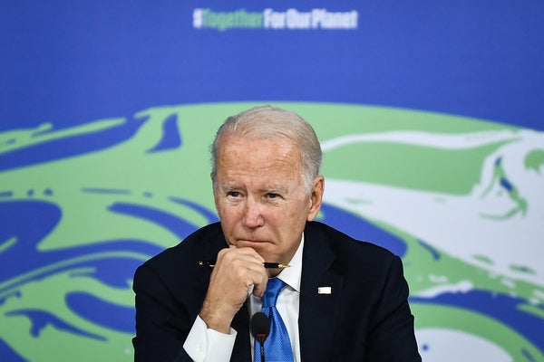 President Joe Biden listens with contemplative expression.