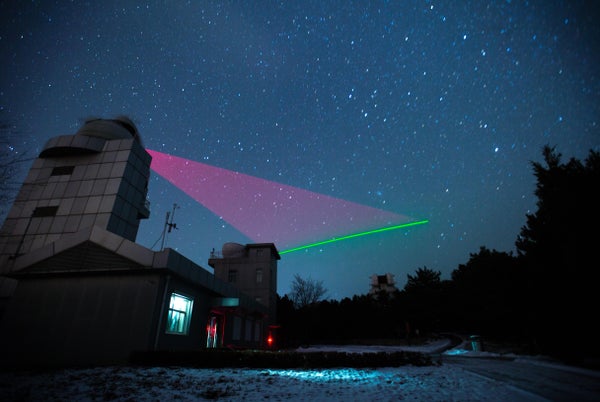 Nighttime view of satellite communication station with colorful lights.