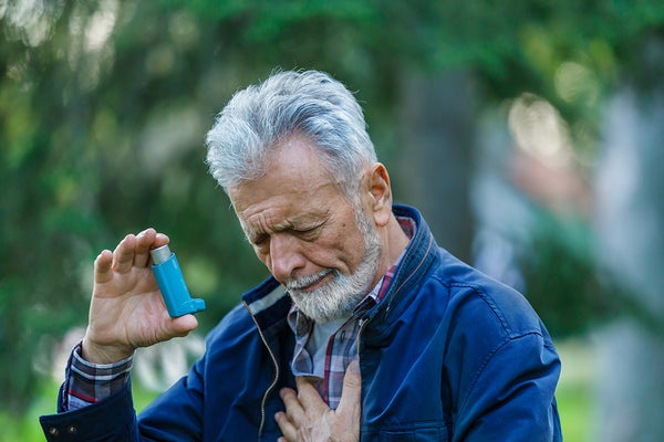 Senior Man With Breathing Problems Using an Asthma Inhaler
