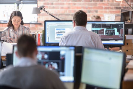 office, workplace, people sitting at desks, working on computers