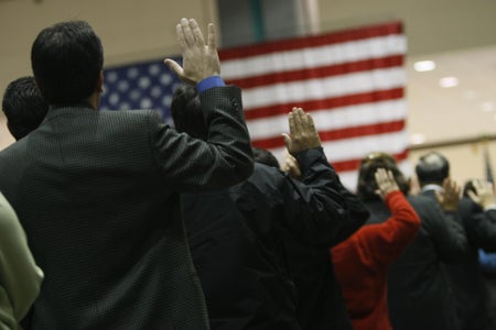 People raising their hands saying the U.S. citizenship oath.