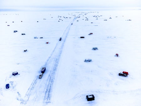 An aerial of ice houses on frozen lake