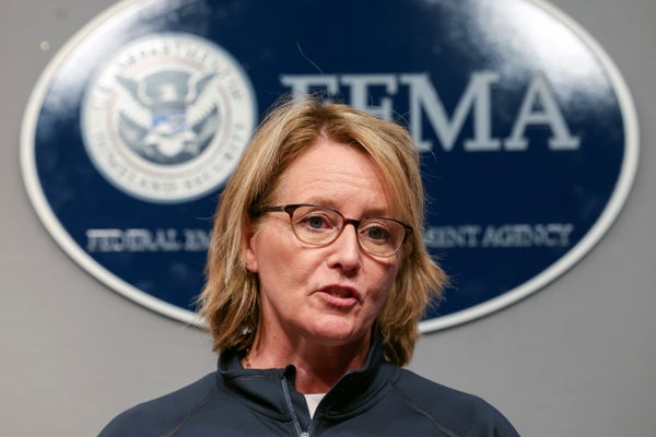 Deanne Criswell speaking in front of a FEMA sign.