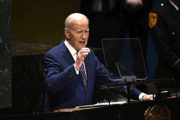 US President Joe Biden at podium in blue suit addressing.