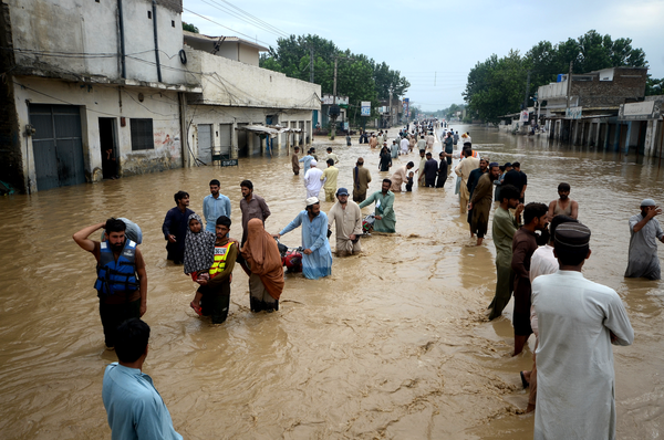 Displaced people wade through a flooded area in Peshawar, Khyber Pakhtunkhwa, Pakistan on August 27, 2022.