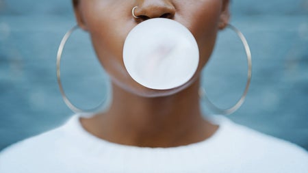 Woman blowing a gum bubble.