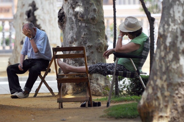 Men on chairs sit during a heat wave in Seville in 2015.