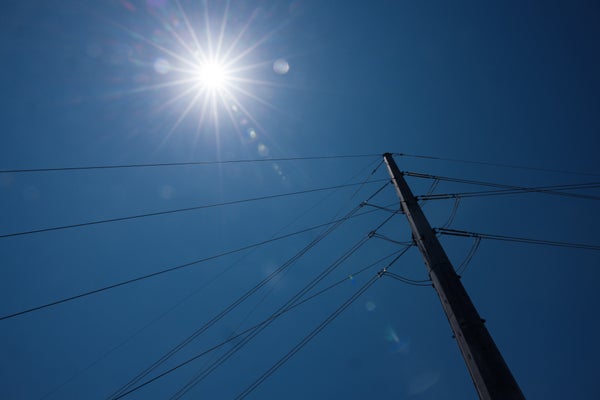 Power grid against sky during heatwave.