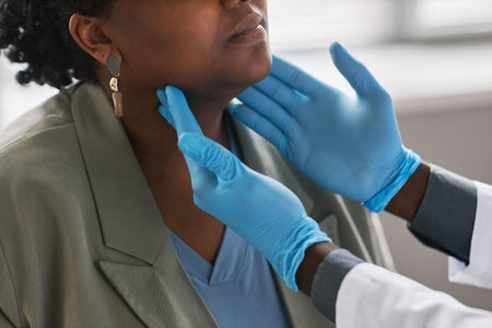 Close up of doctor palpating their female patient's neck