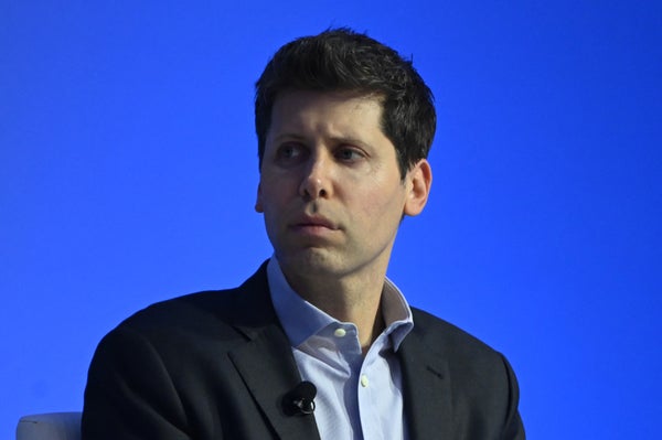 Event photo of Sam Altman in front of a blue background