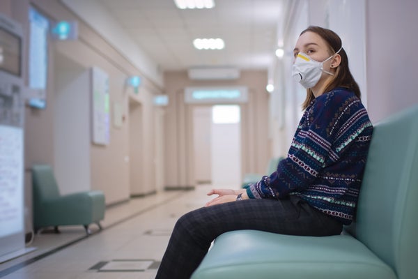 Young girl wearing protective mask in medical clinic.