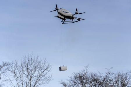 A parcel attached by line to a delivery drone