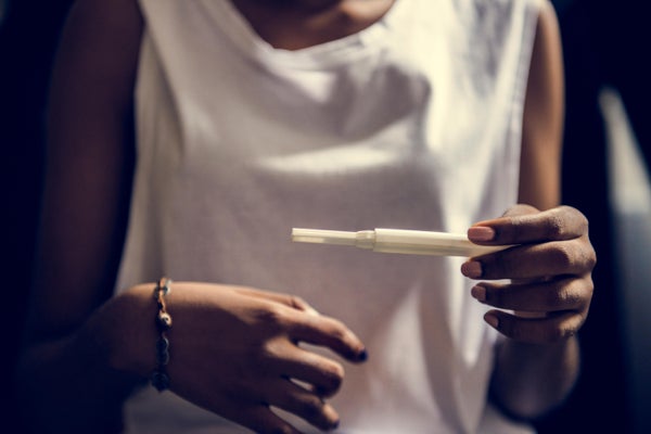 Closeup of black woman with pregnancy test in a hand