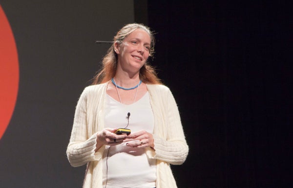 Kim Cobb in white cardigan speaking at the Pop Tech conference in 2010