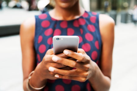 Close up of woman typing on a smart phone.