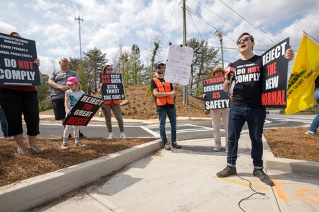 Demonstrators hold signs during a protest.