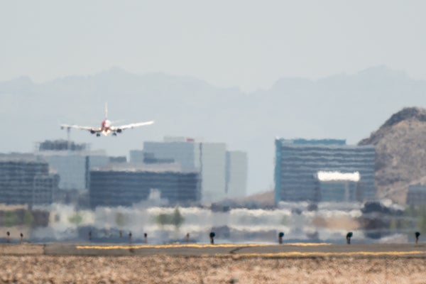 Heat waves ripple across the tarmac as an airplane approaches the runway