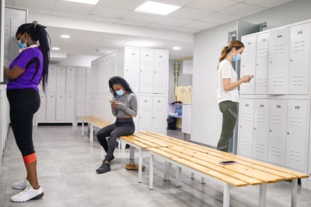 Women wearing face masks in a locker room