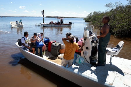 Residents are evacuated from the island by boat.