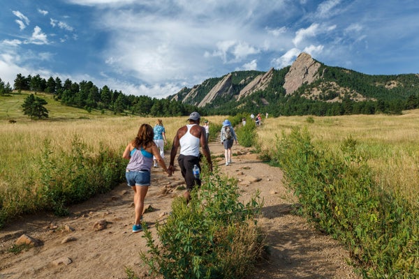HIkers walk on trail towards mountain