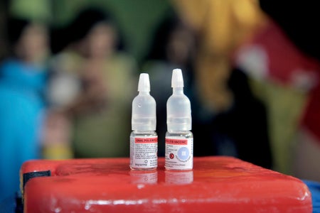 2 small vaccine bottles on a red table