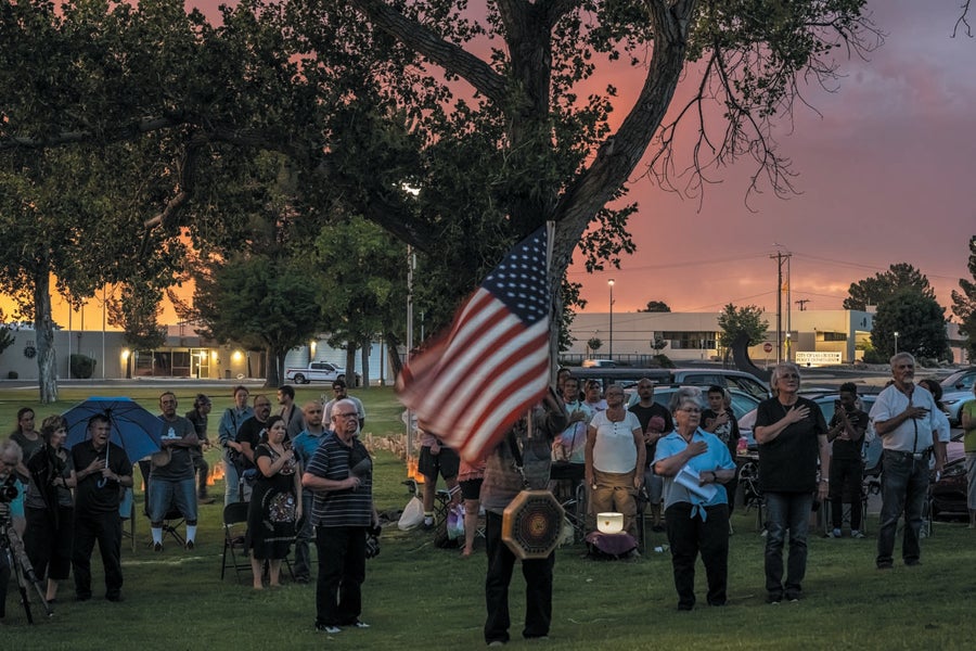 A group of people gathered outside at a memorial.