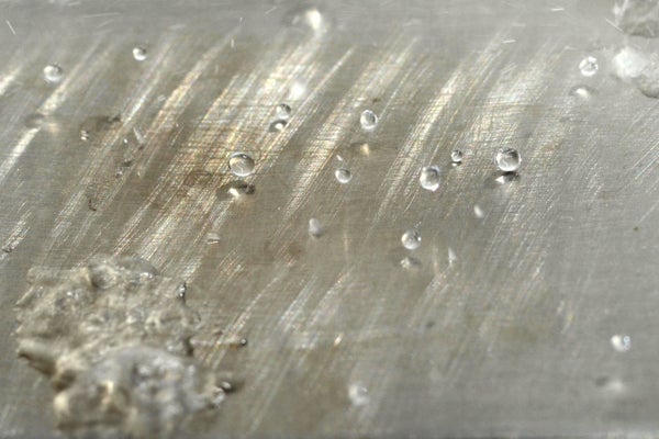 Small water drops on a metal surface.