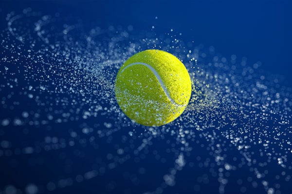 Digital generated image water drops making galaxy pattern around rotating tennis ball on blue background