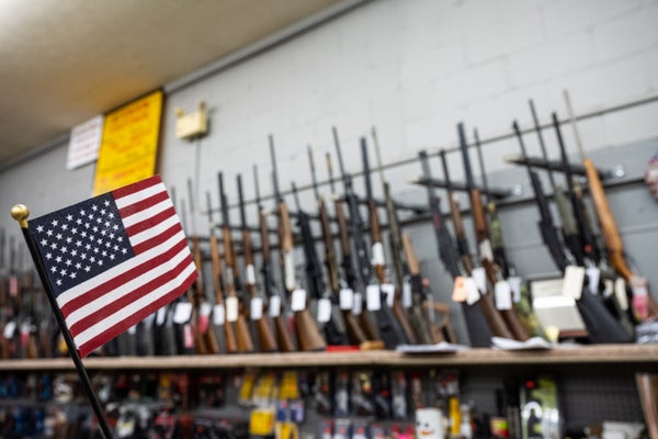 An American flag hangs in front of a gun rack at a gun shop in Kentucky