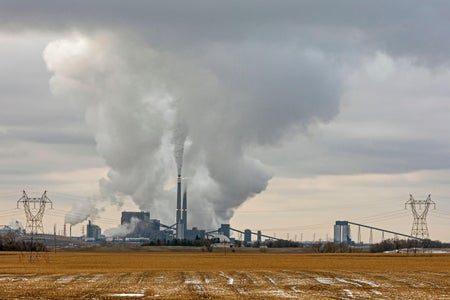 Huge smokestacks send towering plumes of smoke into the sky.
