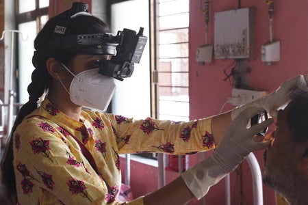 A doctor examines a patient in an examination room in India.