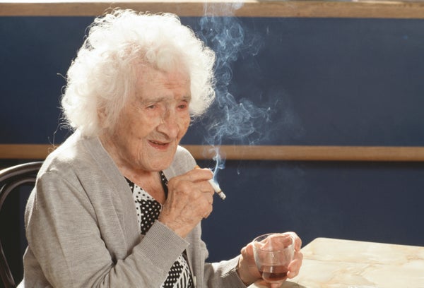 Jeanne Calment enjoys her daily cigarette and glass of red wine on the occasion of her 117th birthday.