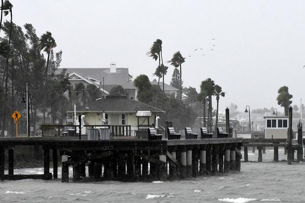 Strong surf and high winds bending palm trees at St. Pete Beach, Florida,
