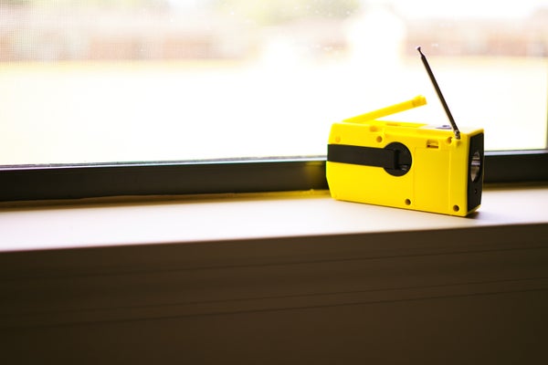 A weather radio sits on a windowsill.