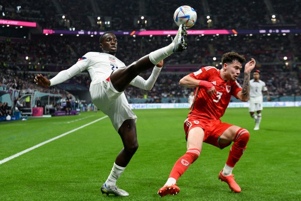 USA's forward #21 Timothy Weah (L) controls the ball ahead of Wales' defender #03 Neco Williams