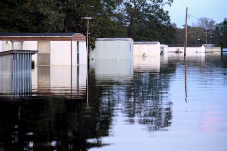 A row of houses stand submerged in floodwaters.