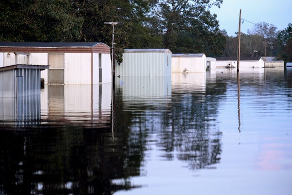 A row of houses stand submerged in floodwaters.