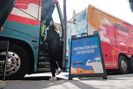 A sign advertising a vaccination bus--in English only.