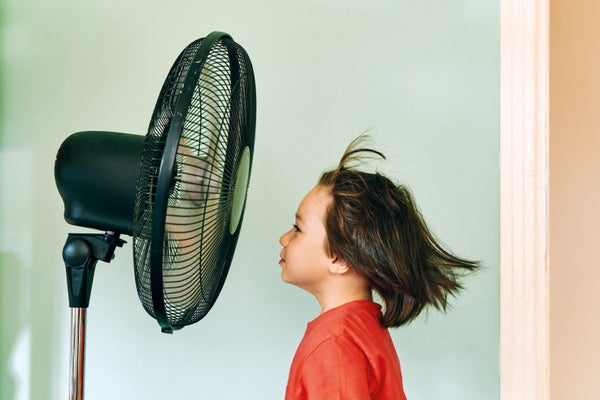 Child is front of electric fan on hot summer day