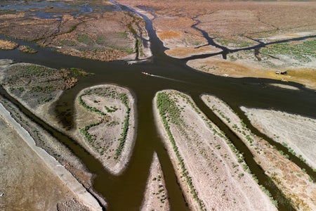 An aerial view shows the drying-up marshes of Chibayish in Iraq with w boat passing through waters.