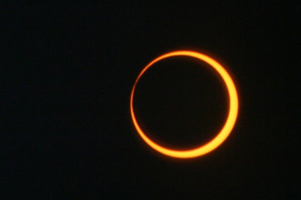 Photograph of a solar eclipse, a glowing orange ring surrounded by black