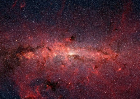 A vast expanse of stars crowds the view amid clouds of cosmic dust.