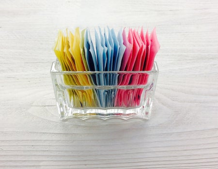 Sugar substitute packets in a glass container.