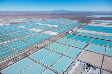 Aerial photograph of Salar de Atacama, Atacama Desert in Chile, with a grid of large, rectangular evaporation ponds filled with milky, opague water that appears to be varying shades of turquoise