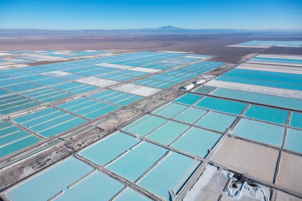 Aerial photograph of Salar de Atacama, Atacama Desert in Chile, with a grid of large, rectangular evaporation ponds filled with milky, opague water that appears to be varying shades of turquoise