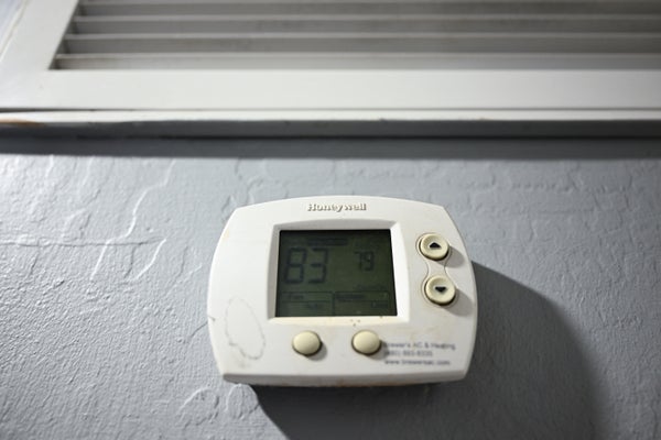 White Thermostat on wall showing 83 degrees.