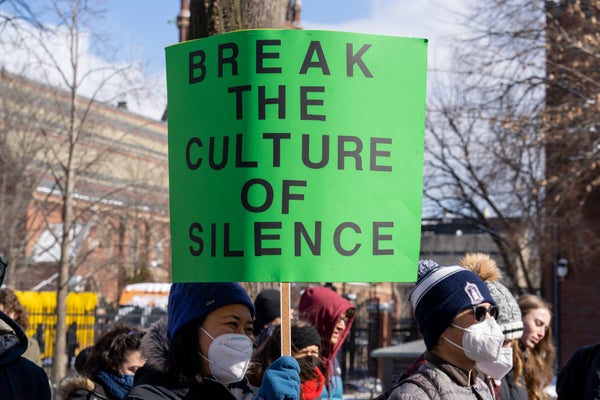 Protestor holds sign on college campus.