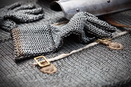 A close-up of metallic silver chain mail, laid out flat on a surface.