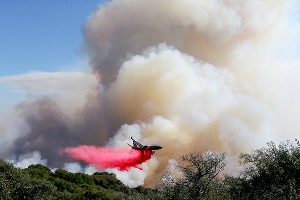 Airplane drops bright red flame retardant