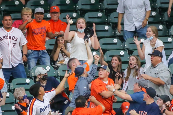 Fans in the stands reach for a home run ball.